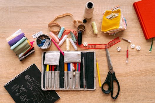 Flat lay of a sewing kit with threads, scissors, and fabric for creative crafting.